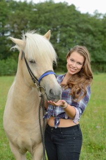 Young woman with a Icelandic horse on a meadow, Germany
