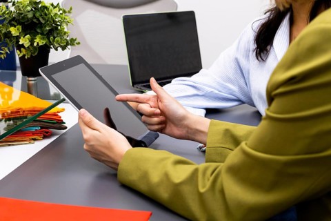 Professionals in an image consulting session analyze digital data on a tablet, surrounded by
