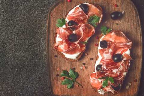 Sandwich with cream cheese, prosciutto with olives, breakfast
