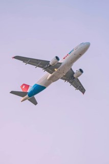 Close-up of a Swiss aircraft flying against the sky, Stuttgart Airport, Germany