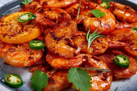 Grilled shrimp, unpeeled, headless, with spices, on a marble table, homemade, no people