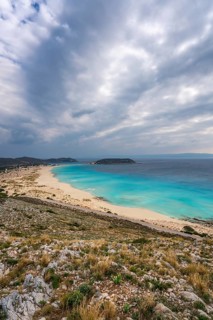 A panoramic view of Simos Beach on Elafonisos Island, Greece, showcasing pristine turquoise waters,