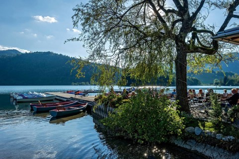 Boats at jetty, boat hire and beer garden, shore of Schliersee, bright backlight, Markt Schliersee,