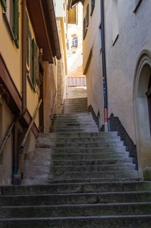 A steep staircase in a narrow old town alley under a blue sky, Schwäbisch Hall, Germany