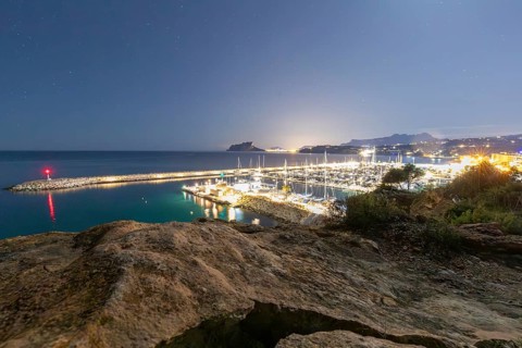 Night descends on Costa Blanca, illuminating the harbor under a starlit sky. The Mediterranean Sea