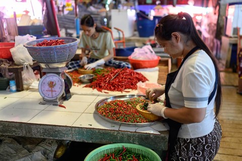 Bangkok, Thailand. February 19th 2025. Local Thai women preparing fresh red chilli peppers at the