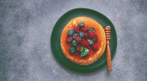 Breakfast, pancakes with berries and honey, top view, homemade, no people