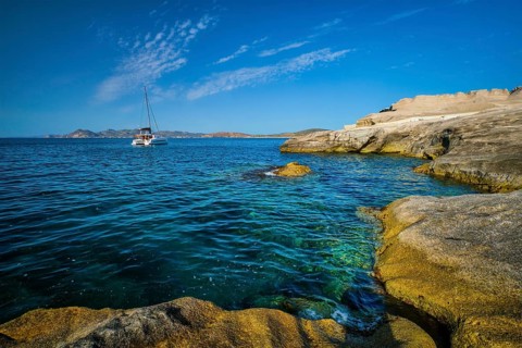 Yacht boat in Aegean sea at white rocks of Sarakiniko Beach, Milos island, Greece