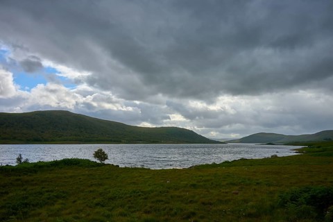 Extensive lake with rolling landscape and cloudy sky, Loch Naver, Lairg, Scotland, United Kingdom,