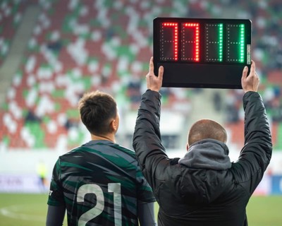 Man shows substitution players numbers during football match in Lubin, Poland