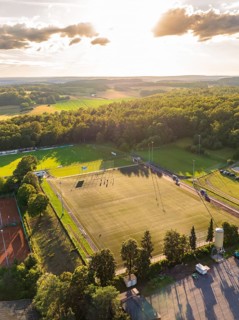 Aerial view of a sports field with a football pitch and trees at sunset, Gechingen, Black Forest,