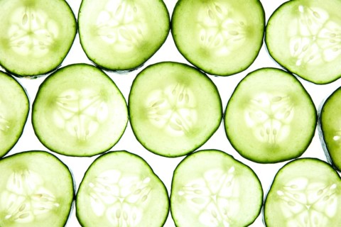 A vibrant pattern of cucumber slices arranged neatly showcases their fresh, green texture on a