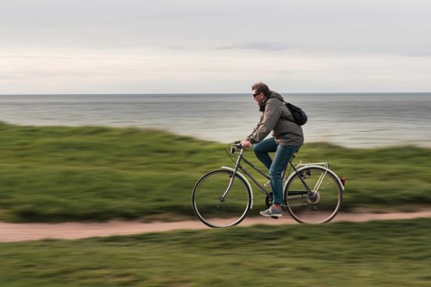 TRZESACZ, POLAND - MAY 1, 2018: The man riding a bike on the cliff above the sea