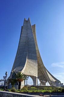 Concrete monument with a modern design against a blue sky, the national independence monument in
