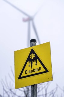 Sign warns of ice shedding from wind turbines, in frost, ice deposits can form on the rotors, ice