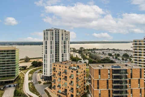 Contemporary residential buildings set against a serene waterfront landscape, showcasing innovative