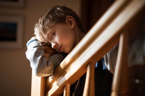 Bored boy by the railing on the stairs