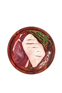Fresh raw duck breasts, on a wooden chopping board, with herbs and spices, on a white background,