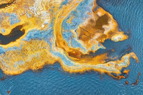 A vivid aerial snapshot featuring a multicolored, abstract landscape with intricate patterns and