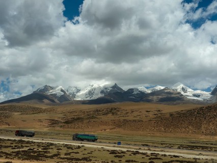 Mountain landscape and lorries in the highlands of Tibet along the Tibet Railway, Tibet, China