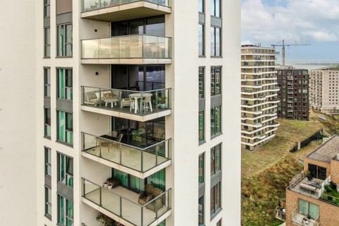 A contemporary residential complex featuring multiple balconies and sleek architecture against a