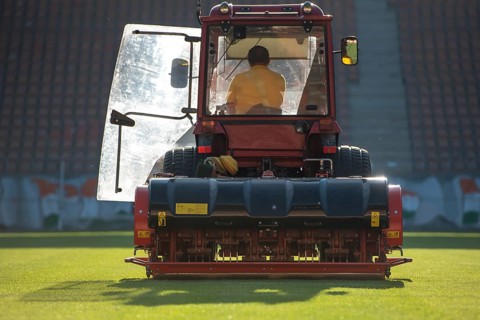 Man in tractor aerating a soccer field