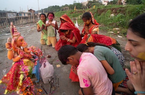 Devotees offer prayers to the Ganesha idol before immerse in the Brahmaputra river, during Ganesh