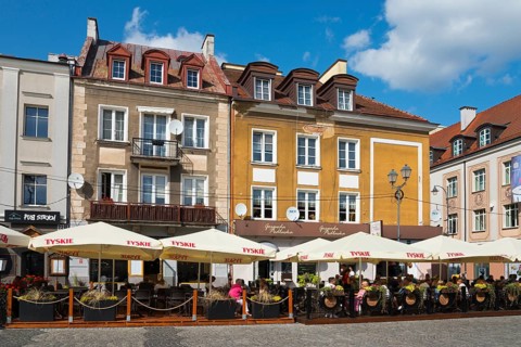 Street cafés with decorative umbrellas and people on a busy square, Kosciuszko Market Square,