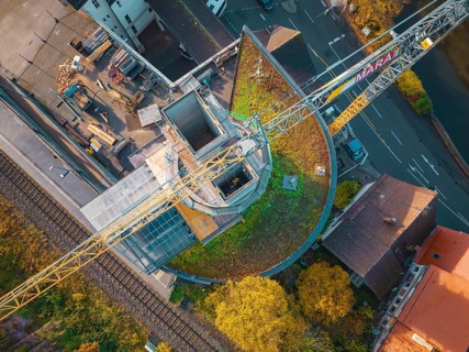 Drone shot of a construction site with crane in an urban environment near a railway line, ZOB Calw