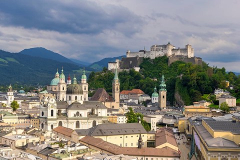 View of Salzburg's historic city centre with Hohensalzburg Fortress under a cloudy sky, Salzburg,