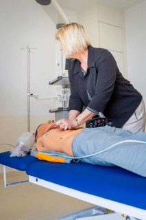 Woman practicing resuscitation on a doll in a medical training room, opening hospital, Calw,