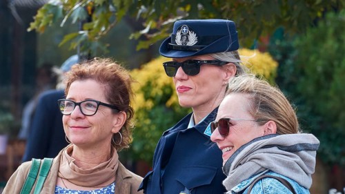 Two woman pose with a uniformed police officer for a photo outdoors, Visit of Federal President
