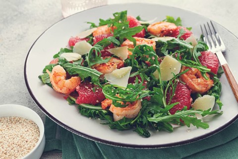 Fresh shrimp salad with arugula, grapefruit, and parmesan served in a bowl