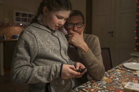 Father and daughter looking for something with their mobile phone, Mecklenburg-Vorpommern, Germany