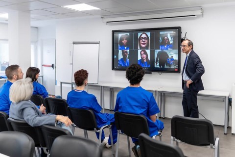 Healthcare professor giving a lecture to a group of young students and remote attendees in an e