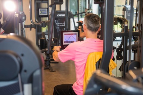 A man performs an exercise with fitness equipment that has a screen, Fitness TSV Calw, Germany