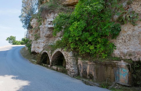 A winding road with stone walls and lush vegetation next to it, spring, Afytos, Afitos, Athitos,