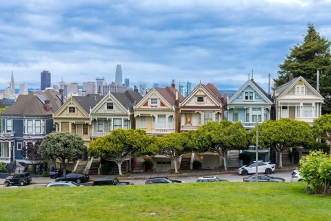 Iconic painted ladies victorian homes lining alamo square park with modern san francisco downtown