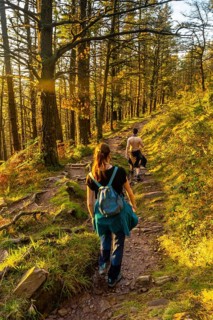 A couple on the trail at sunset of Mount Adarra in the town of Urnieta near San Sebastian, Gipuzkoa