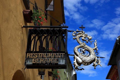Romania, Restaurant Berarie, restaurant sign with dragons in the historic old town of Sighisoara,
