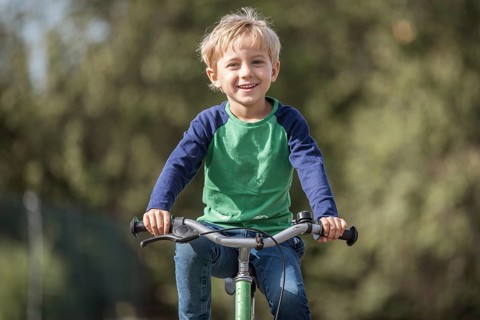 Smiling little boy ride on a bicycle
