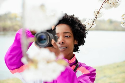A talented African American woman photographer skillfully captures the beauty of cherry blossoms