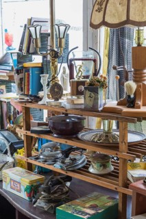 Various objects for sale on wooden shelves inside second hand goods and chattels store, Quebec,