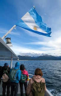 Ushuaia, Tierra del Fuego, Argentina, tourists on an excursion boat flying the Argentinian flag in