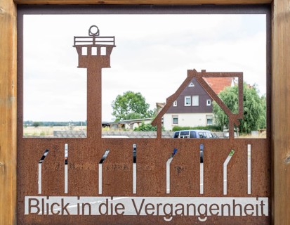 View into the past with shop window with border fence and border tower in front of a still existing