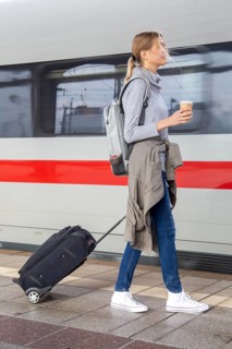 Young woman on the railway track while a train arrives
