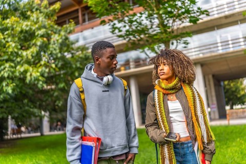Diverse students back to university walking and talking outside the building