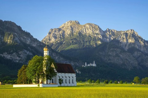 Baroque church St. Coloman, behind it Neuschwanstein Castle and the mountain Saeuling, 2047m,