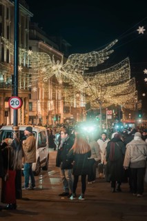 Angel decoration and lights accompany people on busy street, New Year's Eve London, Great Britain