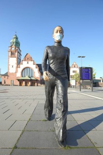 Walking Woman sculpture by Sean Henry 2013, modern art, life-size, woman wearing face mask, during